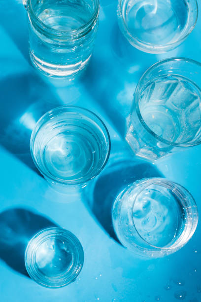 istock Flatlay arrangement with sparkling water in various glasses , summer drink concept. Top view, Blue background, selective focus 948648292