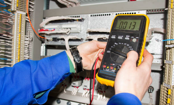 istock electrician measures voltage by tester. multimeter is in hands of engineer in electrical cabinet 948651450