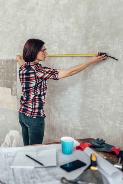 woman measuring wall in kitchen - home decorating interior designer blueprint planning imagens e fotografias de stock