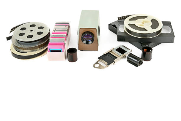 istock Old videocassettes and video projector with slides isolated on white background. 948654344