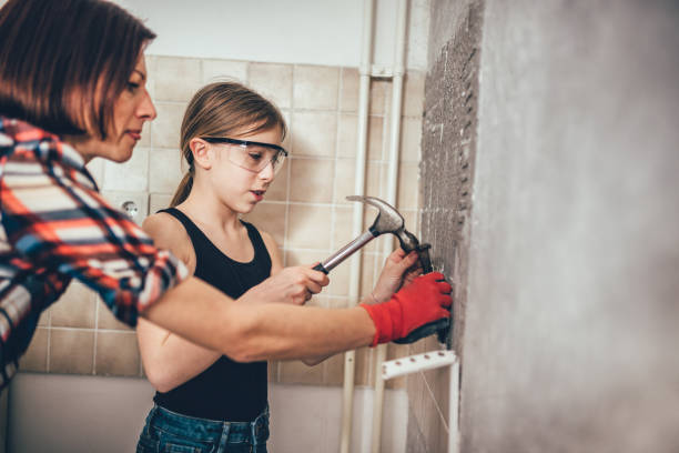 Daughter and mother removing kitchen wall tails Daughter and mother removing old wall tails in the kitchen girl with a hammer stock pictures, royalty-free photos & images