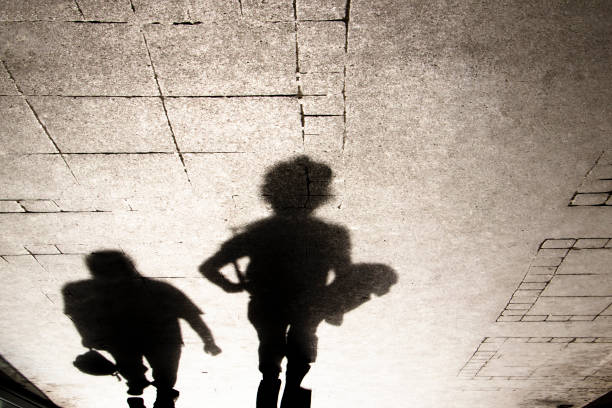 istock Shadow silhouette of people on city sidewalk 948671176