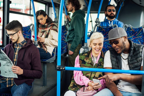 istock Mixed race couple in bus using phone 948671968
