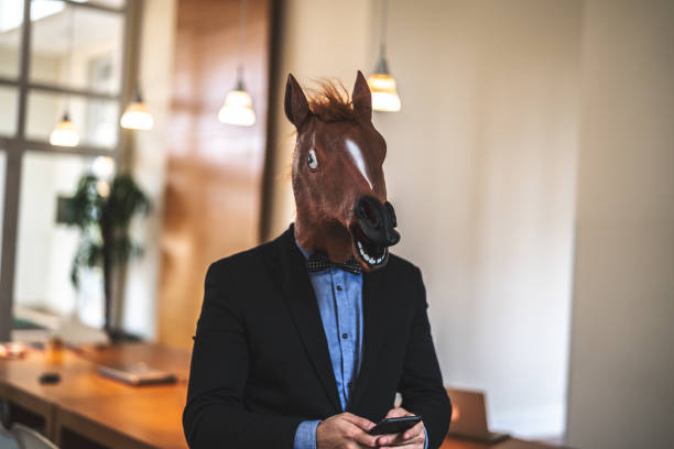 istock Business man with Horse Mask Using Mobile at Office 948675860