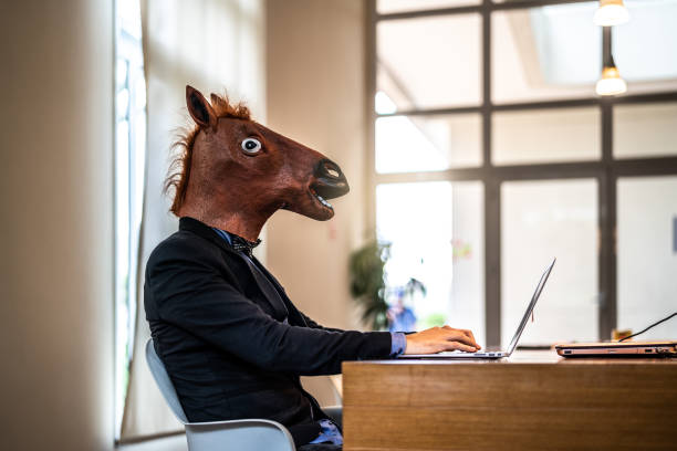 zakenman met het paard masker werken op kantoor - gekke paarden stockfoto's en -beelden