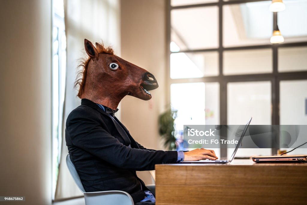 Business man with Horse Mask Working at Office Bizarre Horse Stock Photo