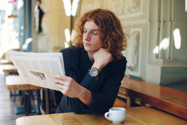 istock Young man reading a newspaper in the morning 948678248