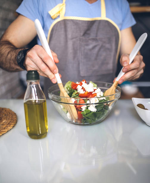 istock Man in apron preparing salad in kitchen 948687418