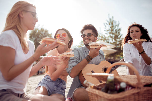 istock Group of happy young people having a picnic on the beach 948690874