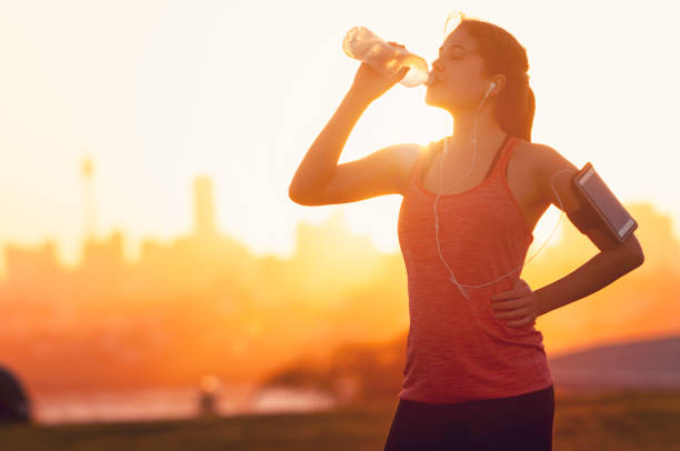 istock Silhouette of a woman drinking form a water bottle. 948693430