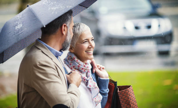 rainy walk home from shopping. - women common 40s candid imagens e fotografias de stock