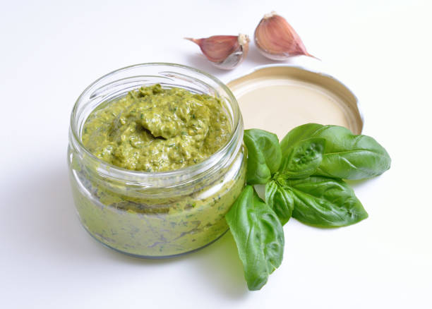 istock Pesto sauce in a glass jar with basil and garlic. 948698250