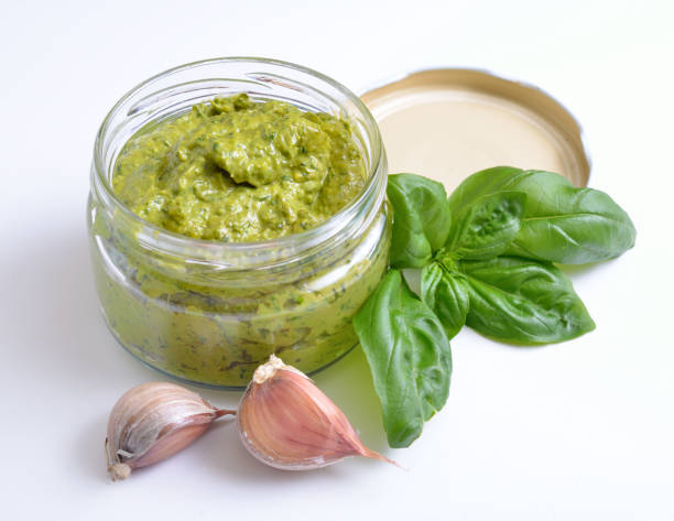 istock Pesto sauce in a glass jar with basil and garlic. 948698412