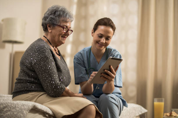 istock Young nurse showing senior women digital tablet 948707860