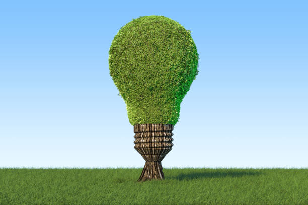 istock Renewable energy concept. Tree shaped as light bulb on the green grass against blue sky, 3D rendering 948709538