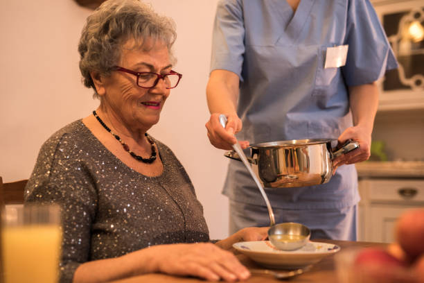 istock Nurse helping senior women with lunch 948712096