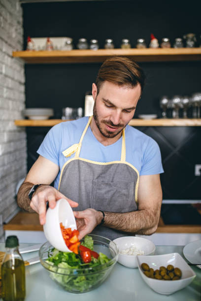 istock Man preparing salad for dinner with friends 948712372