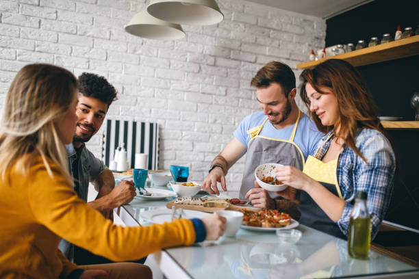 istock Mixed race couples laughing and preparing dinner together 948732748