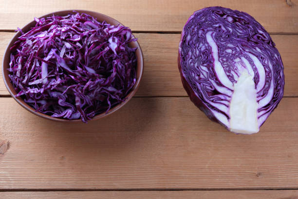 istock Chopped purple cabbage on a wooden background, red cabbage in a clay bowl, copy space, rustic style, vegetarian food, half fresh cabbage, minimalism, art 948739886