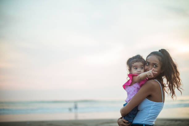 istock Mother and daughter at the beach 948740022