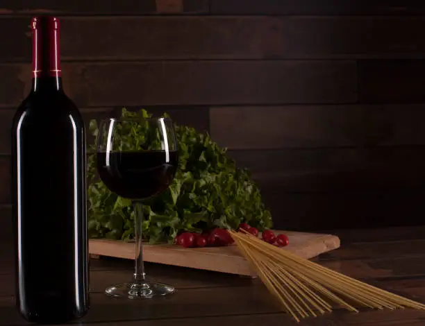 Bottle of wine and glass with a background that suggests a romantic dinner