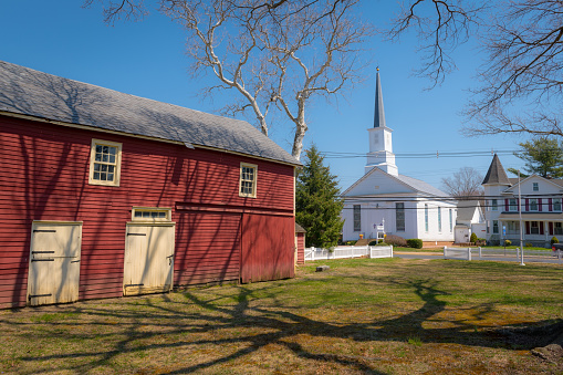 Englishtown, NJ, USA - April 14, 2018: A scenic view of a barn and church near the historic Village Inn built in 1726 in Englishtown New Jersey.