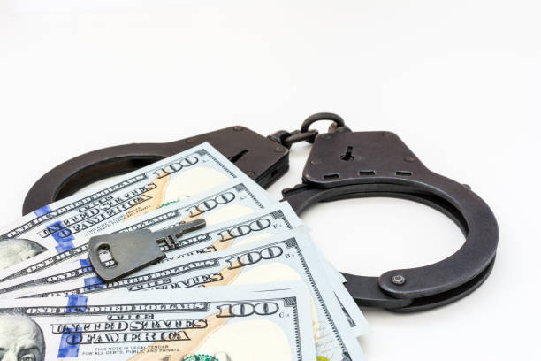 istock hundred dollar bills are on handcuffs on a white background 948749382