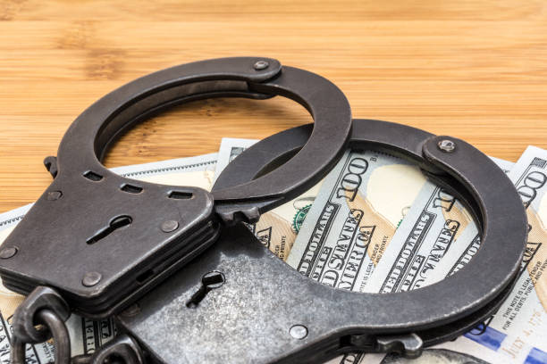 istock black metal handcuffs lying on the 100 dollars banknotes 948749408