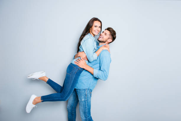istock Happy man carrying his pretty wife on gray background 948751766
