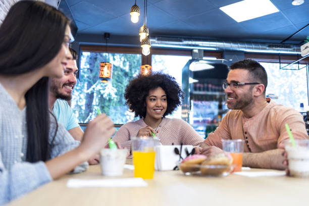 istock Young people talking and eating ice cream in cafe 948751796