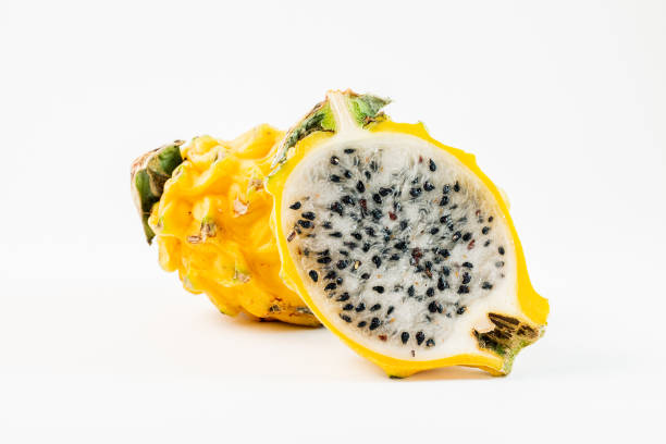 Two yellow dragon fruits on a white background.  One of the fruits is sliced in half. Two yellow dragon fruits on a white background.  One of the fruits is sliced in half. pitaya stock pictures, royalty-free photos & images