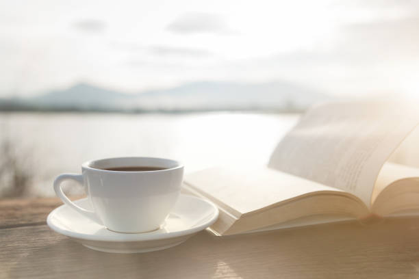 istock Cup of coffee and book on a wooden table 948770416