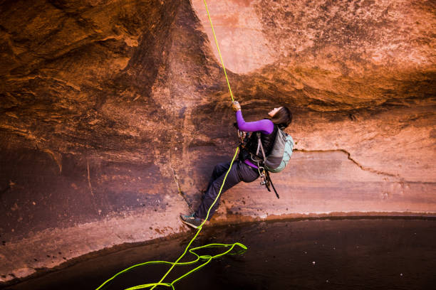 istock Physically Fit Athletic Woman Rappelling Off a Cliff In Moab 948772570