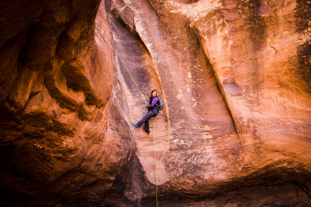 Athletic Young Woman Rappelling Near Moab Utah