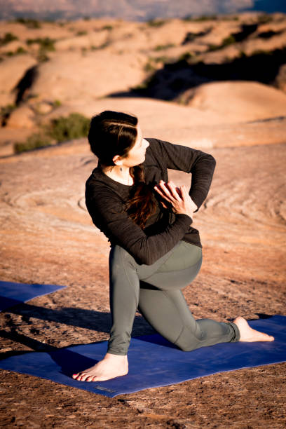 istock Woman Performing Twisting Yoga Pose at Dusk in Moab 948772670