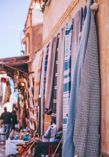 textilien auf der überfüllten market square in marrakesch - craft market morocco shoe stock-fotos und bilder