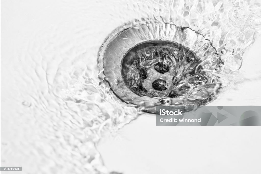 draining in washbasin water draining in washbasin Drain Stock Photo