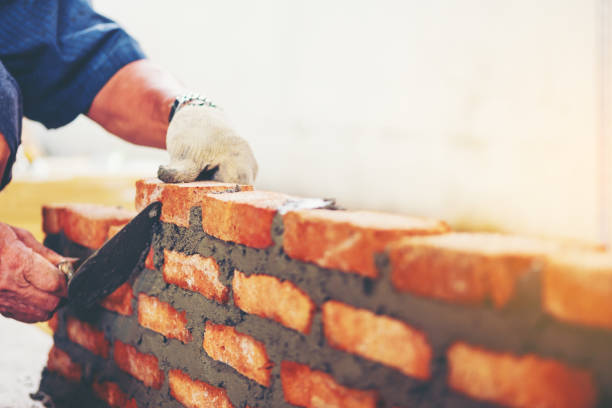 istock Cropped Image Of Manual Worker Making Brick Wall At Construction Site 948789728