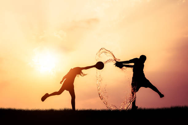 Children playing splash water on Songkran silhouette.