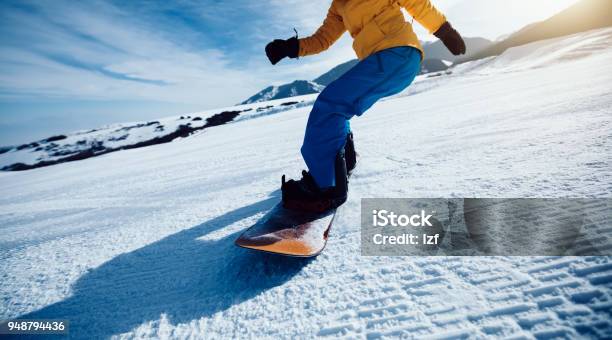 One Snowboarder Snowboarding In Winter Mountains Stock Photo - Download Image Now - Snowboarding, One Woman Only, Activity