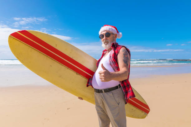 istock Australian Santa With a Surfboard at the Beach in Summer 948798196