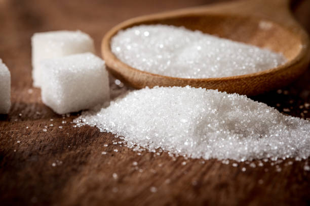 istock Close up a sugar cubes and cane in wooden spoon on the table 948798836