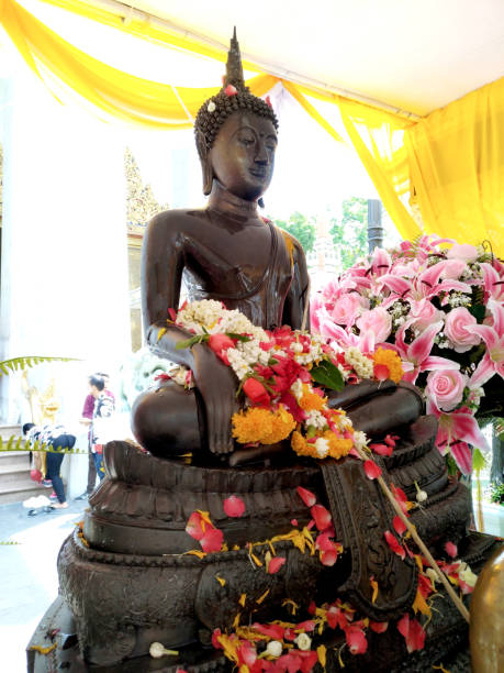 bangkok tailandia, 15 de abril de 2018 festival de songkran (año tailandés), la gente ir al templo y vierta el agua sobre la estatua de buda, dedicar corona y flores como adoran - pay as you go fotografías e imágenes de stock