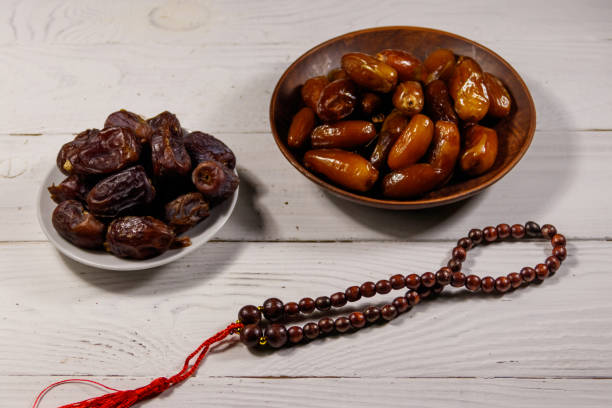 istock Dates fruit and prayer beads on white wooden table 948809108