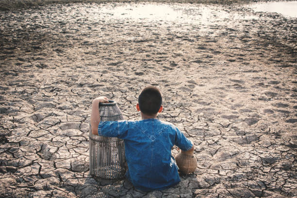 istock High Angle View Of Boy Sitting On Field During Drought 948816506