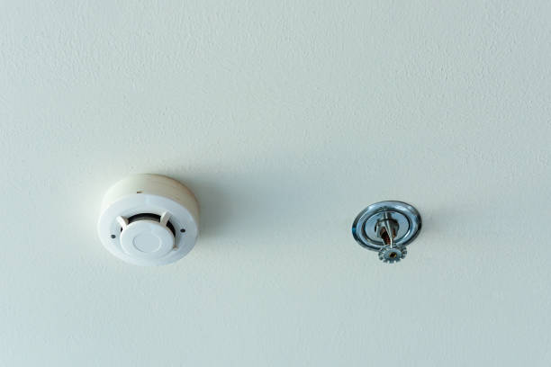 istock Smoke detector and fire sprinkler on a ceiling. 948825696