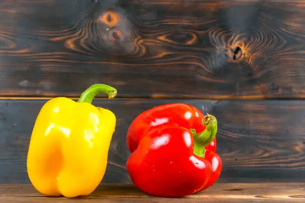 red and yellow bell peppers on wooden background