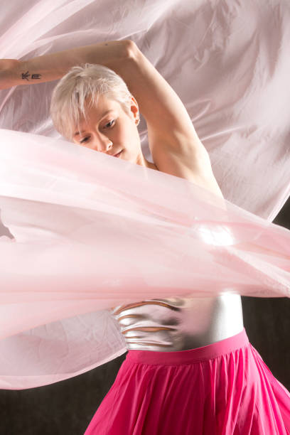 istock Beautiful young woman dancer twirling pink chiffon fabric. 948826678