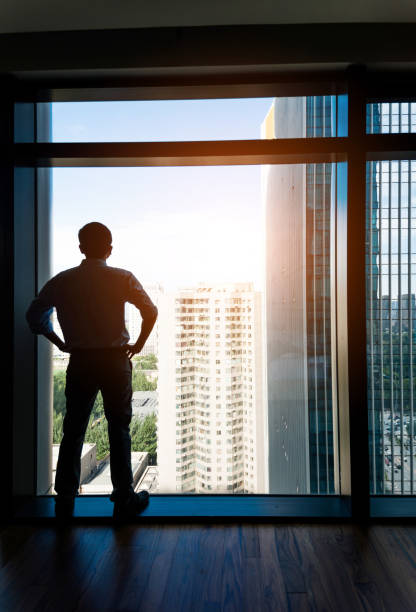 istock Businessman through the window looking the city 948830006
