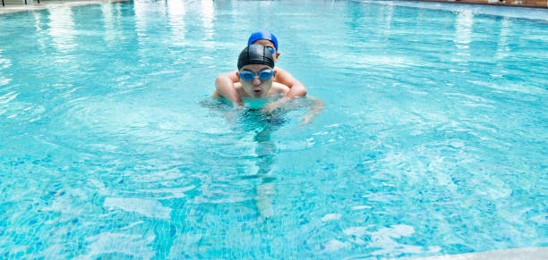 child swimming and splashing in a blue pool,with copy space